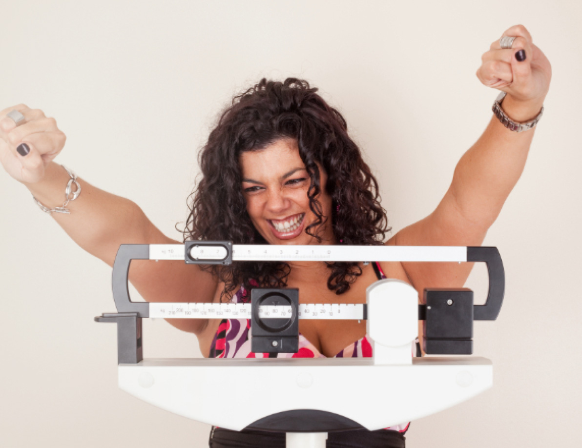 Woman celebrating her success on a scale