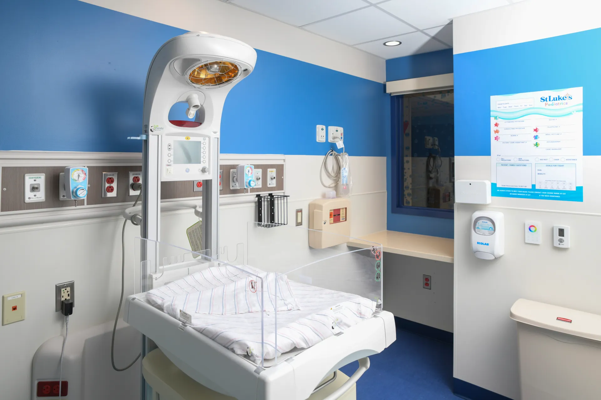 Hospital room with a specialized newborn baby bed in the center